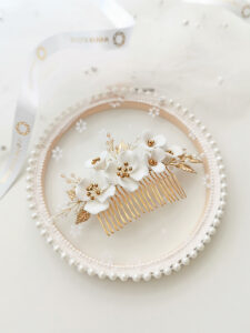 Češljić za kosu s bijelim porculanskim cvjetovima. Prikladan za vjenčanja i razne svečane frizure.