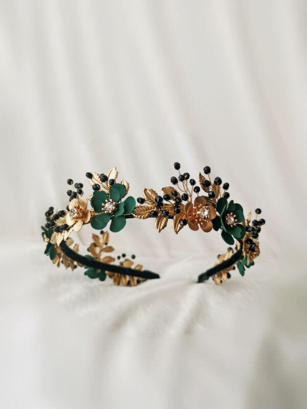 Raskošan cvjetni rajf za kosu bogato ukrašen floralnim motivima u kosi ostavlja dojam krune. Ručno izrađen od metalnih smaragdno zelenih i zlatnih cvjetića, crnih Swarovski perlica i zlatnih listića.