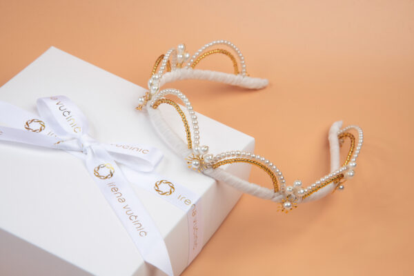 Moderna kruna za vjenčanje s fleksibilnim lukovima optočenim biserima i zlatnim staklenim perlicama.