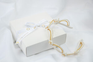 Moderna kruna za vjenčanje s fleksibilnim lukovima optočenim biserima i staklenim zlatnim perlicama.