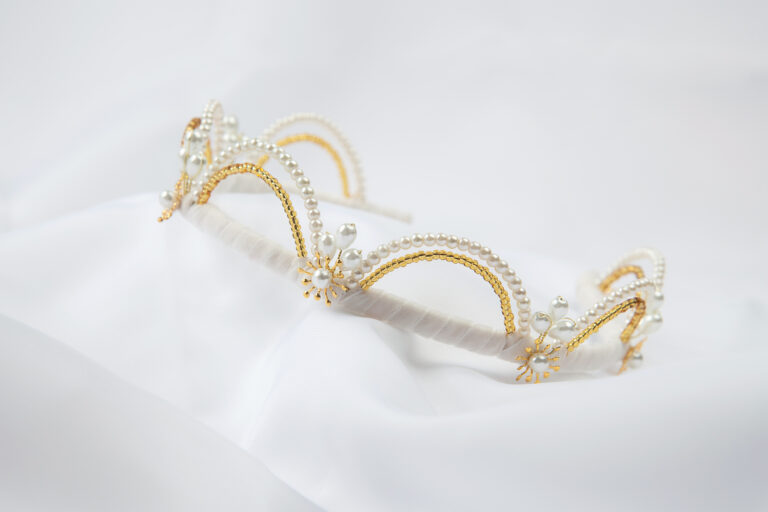Moderna kruna za vjenčanje s fleksibilnim lukovima optočenim biserima i staklenim zlatnim perlicama.